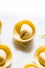 Nahaufnahme von ungekochten Tortellini auf weißer Tischplatte — Stockfoto