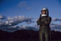 Confiada astronauta de pie en la naturaleza por la noche - foto de stock