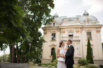 Одружена пара обіймає поруч розкішну будівлю — стокове фото