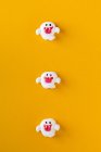 Хэллоуин конфеты в форме призрака на оранжевом фоне — стоковое фото