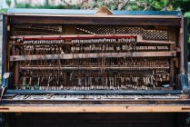 Поврежденное внутри древнего ржавого фортепиано на улице — стоковое фото