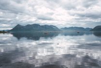 Lago transparente em montanhas sob céu nublado — Fotografia de Stock