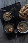 Sopa de crema de champiñones con croutons en cuencos en bandeja sobre mesa de madera - foto de stock