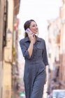 Веселая женщина говорит по смартфону на улице — стоковое фото