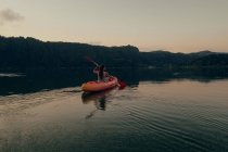 Женщина, плывущая на лодке в чистом озере — стоковое фото
