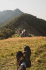 Ноги анонимной женщины-путешественницы на фоне травянистого склона холма в солнечный день в Болгарии, Балканы — стоковое фото