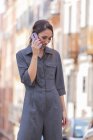Fröhliche Frau spricht auf der Straße mit Smartphone — Stockfoto