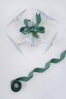 Беспилотник завернутый в рождественский подарок с зеленой лентой на белом фоне — стоковое фото