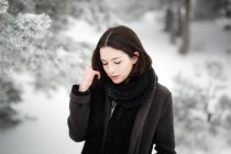 Jeune femme en vêtements chauds marchant sur une journée d'hiver venteuse dans une magnifique campagne — Photo de stock