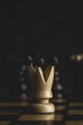 Primo piano di pezzi di gioco e scacchi su sfondo scuro — Foto stock