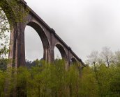 Majestuoso viaducto bajo cielo nublado - foto de stock