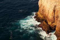 Costa del mare con alte scogliere e acqua blu — Foto stock