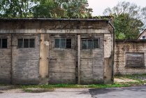 Стара будівля з похмурими цегляними стінами та дерев'яними дверима на вулиці маленького поселення — стокове фото