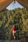 Женщина на балконе с видом на лес — стоковое фото