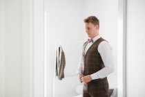 A groom buttoning his waistcoat — Stock Photo