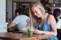 Жінка п'є і їсть в кафе — стокове фото