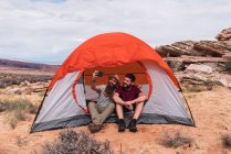Путешественники делают селфи со смартфоном возле палатки — стоковое фото