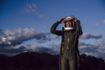 Уверенная в себе счастливая женщина-астронавт, стоящая на природе вечером — стоковое фото