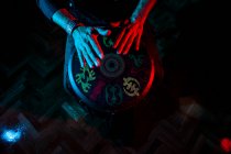 Young percussionist practicing technique with the tam tam or drum, colored lighting in red and blue.hands view — Stock Photo