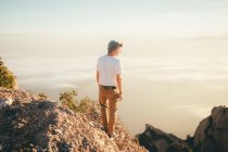 Back view of young guy in casual outfit standing on mountain and admiring picturesque view of nature in Barcelona, Spain — Stock Photo
