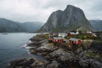 Kleines Dorf am felsigen Ufer in den Bergen in bewölkt — Stockfoto