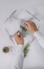 Mani maschili decorazione drone avvolto come regalo di Natale con ramo di abete e spago su sfondo bianco — Foto stock