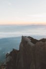 Anonyme Person bei Sonnenaufgang auf Klippe — Stockfoto