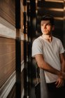 Nachdenklicher junger Mann steht im Gebäude im Sonnenlicht — Stockfoto