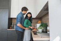 Casal alegre cozinhar na cozinha juntos — Fotografia de Stock