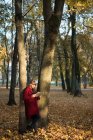 Donna che legge volume appoggiato ad un albero — Foto stock