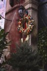 Grinalda de Natal decorado com ouro e bolas coloridas, pendurado fora de casa — Fotografia de Stock