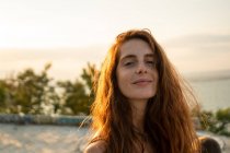Attraente giovane femmina sorridente e guardando la fotocamera mentre in piedi su sfondo sfocato della natura incredibile nella giornata di sole in Bulgaria, Balcani — Foto stock