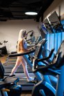 Athletische blonde Frau joggt auf Laufband im Fitnessstudio — Stockfoto