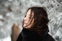 Jeune femme en vêtements chauds marchant sur une journée d'hiver venteuse dans une magnifique campagne — Photo de stock