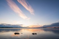 Superficie del tranquillo lago blu con cielo drammatico al tramonto — Foto stock