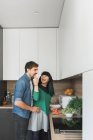 Cheerful couple cooking in kitchen together — Stock Photo