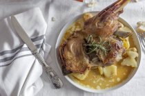 Roasted lamb with potatoes served on plate on white tablecloth — Stock Photo
