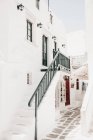 Edificio encalado con escaleras y pequeña tienda abajo en Mykonos, Grecia - foto de stock