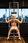 Atlético loira mulher no sportswear fazendo exercício no ginásio — Fotografia de Stock