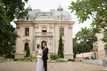 Супружеская пара, обнимающая роскошное здание — стоковое фото