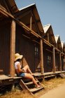 Mulher turística apoiando-se no edifício de madeira — Fotografia de Stock
