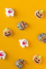 Dekorierte Halloween-Bonbons auf orangefarbenem Hintergrund — Stockfoto
