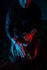 Giovane percussionista pratica tecnica con tam tam o tamburo, illuminazione colorata in rosso e blue.hands vista — Foto stock