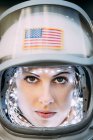 Fille confiante portant vieux casque de l'espace avec drapeau américain signe sur fond de feuille — Photo de stock
