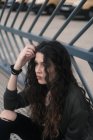 Young brunette sitting on metal path — Stock Photo