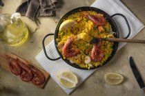 Традиционная испанская паэлья маринера с рисом, креветками, кальмарами и мидиями в кастрюле с ингредиентами — стоковое фото