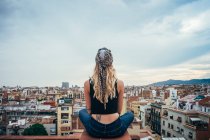 Giovane donna seduta sul tetto — Foto stock