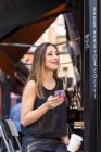 Frau mit Getränk und Smartphone in der Nähe von Café — Stockfoto