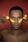 Portrait of of African American man with yellow smears of paint on face — Stock Photo