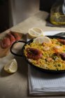 Paella marinera tradicional española con arroz, gambas, calamares y mejillones en sartén con ingredientes - foto de stock